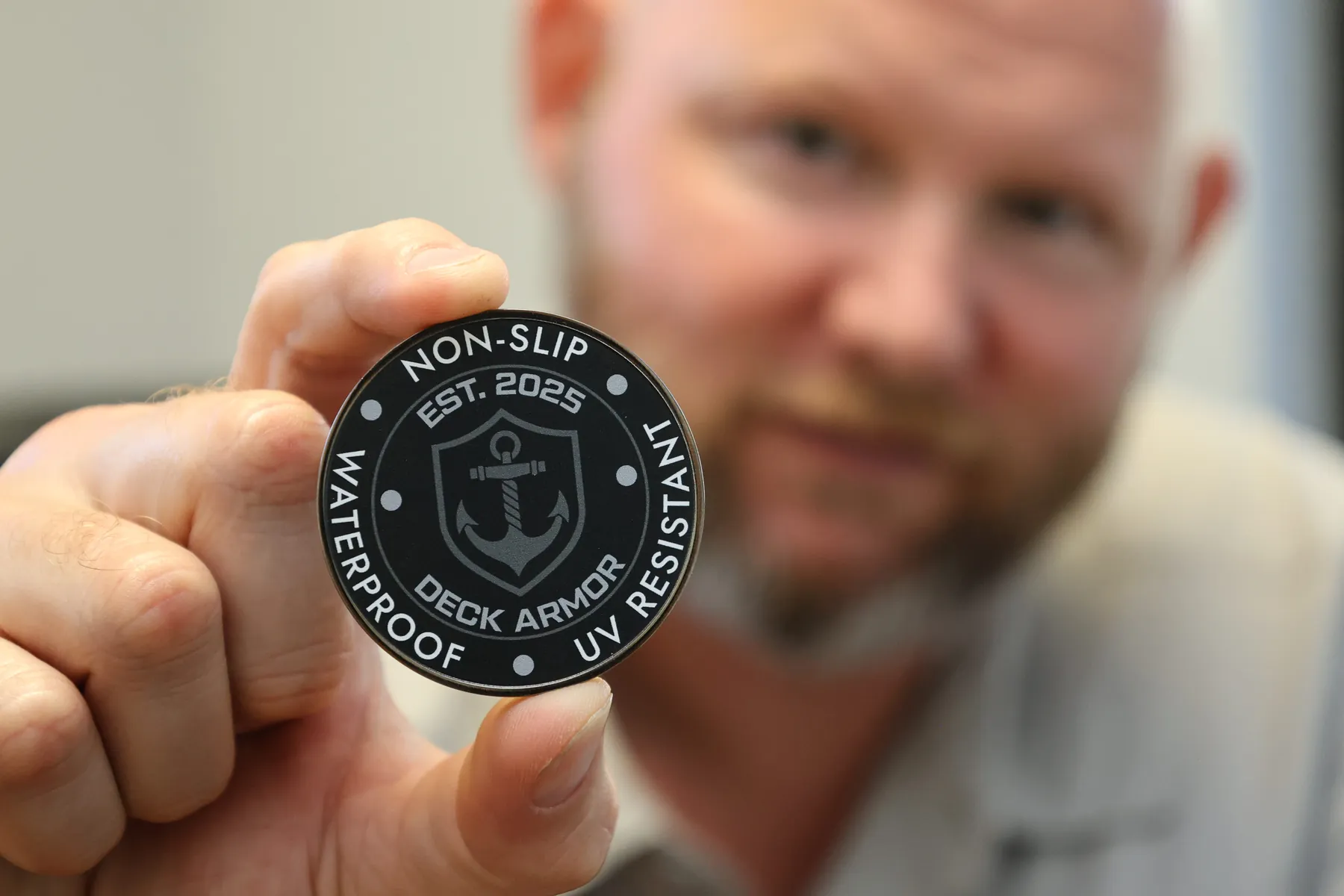 David Odell holding the Deck Armor challenge coin